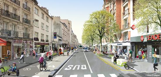 Eine Straße in Paris mit breiten Gehwegen, Fahrradwegen, Bäumen und Busspur