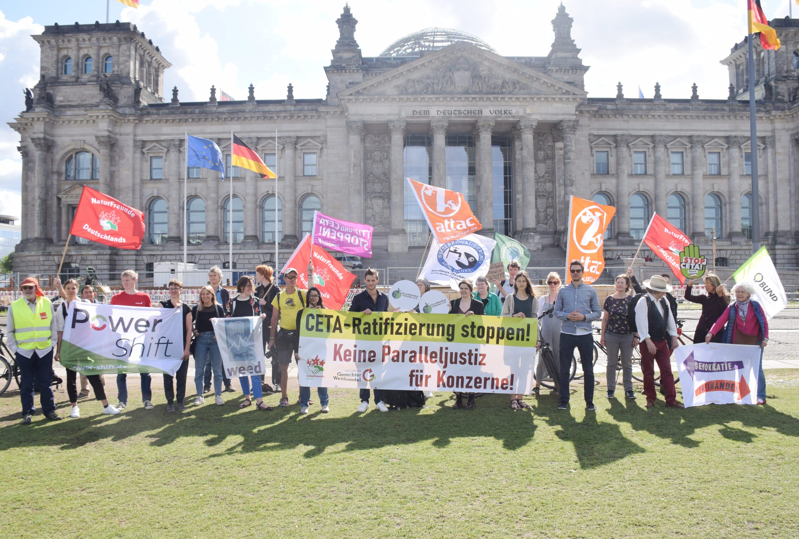 Menschen verschiedener NGOs stehen mit Transparenten vor dem Bundestag. Auf einem Banner steht: CETA-Ratifizierung stoppen! Keine Paralleljustiz für Konzerne