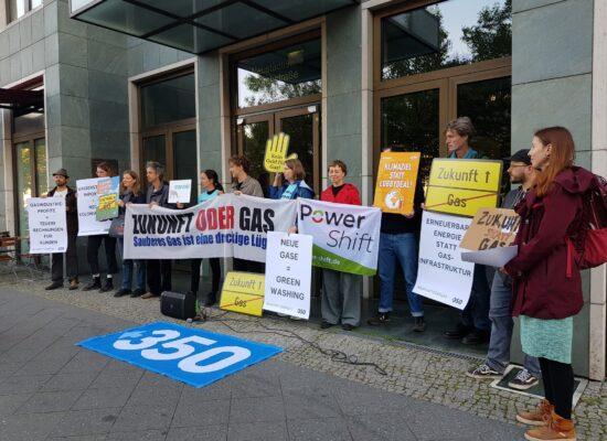 Menschen stehen mit Protestschildern vor dem Gebäude des Lobbyverbandes “Zukunft Gas”