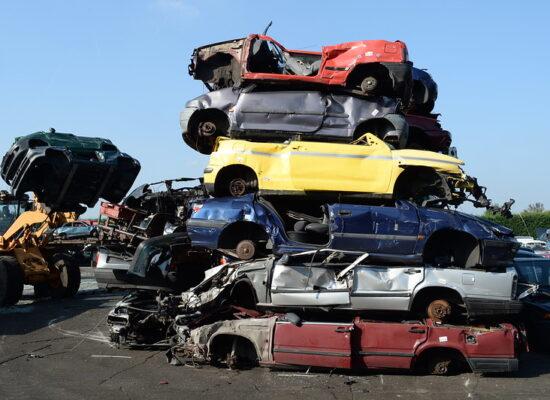 Das Bild zeigt mehrere übereinander gestapelte verschrottete Autos.